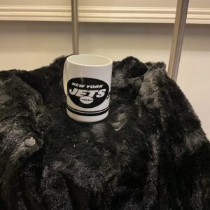 A coffee mug sitting on top of a fur blanket.