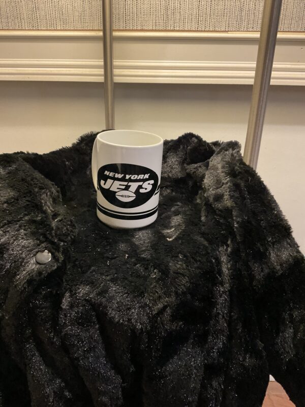 A coffee mug sitting on top of a fur blanket.