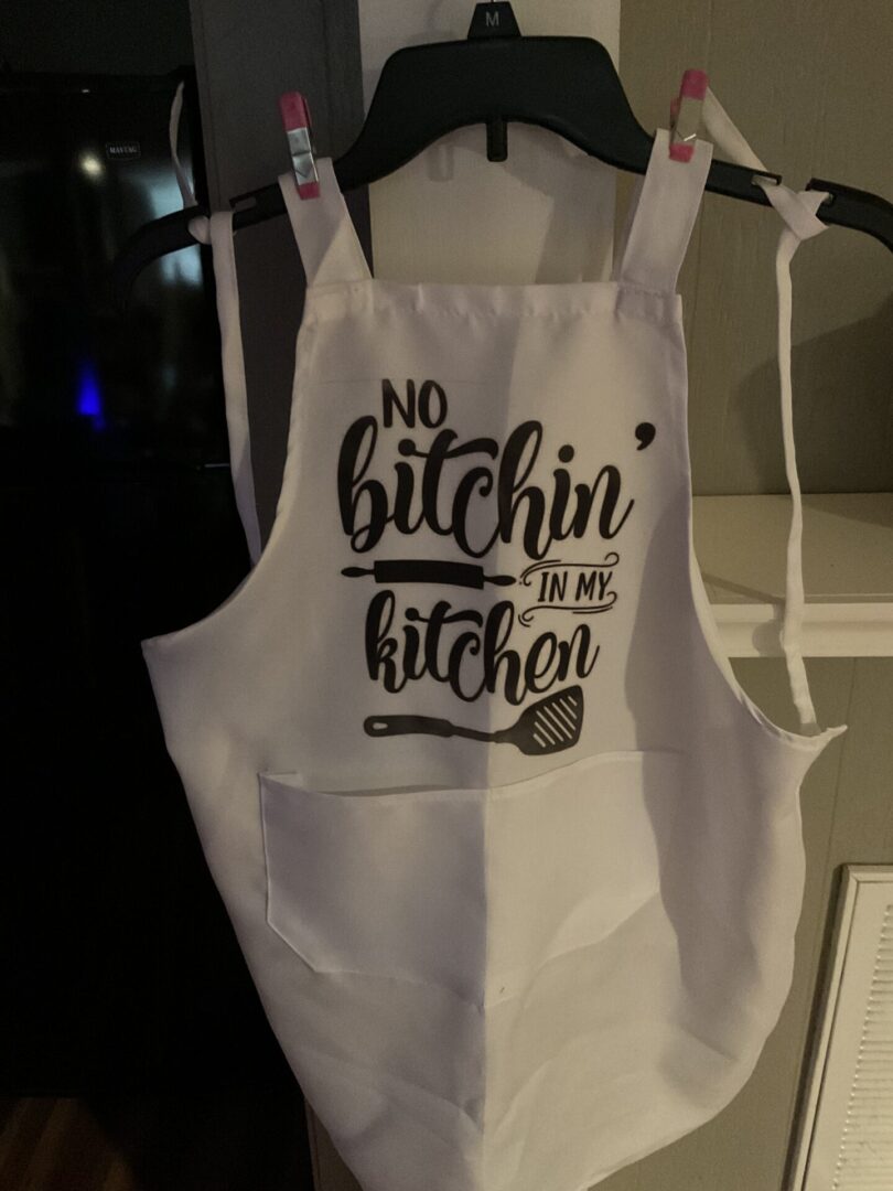 A white apron with an image of a spoon and a knife.