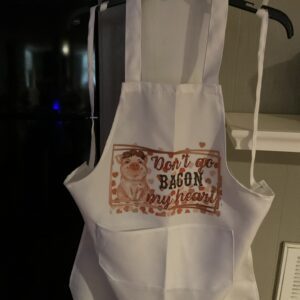 A white apron with an image of bacon on it.