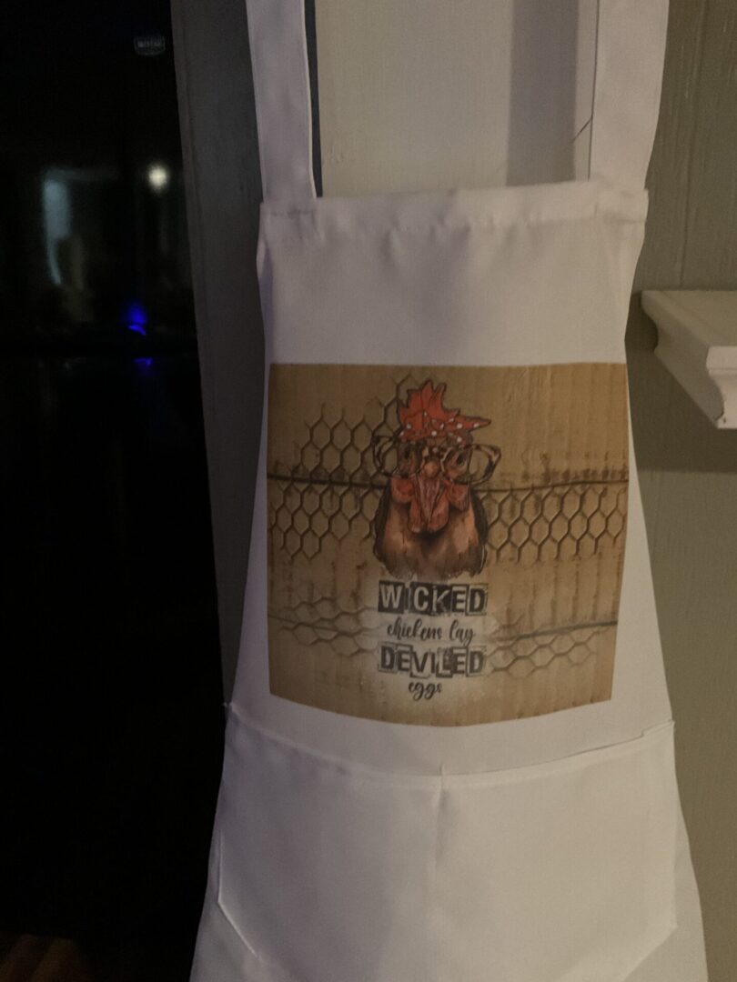 A white apron with an image of a chicken on it.