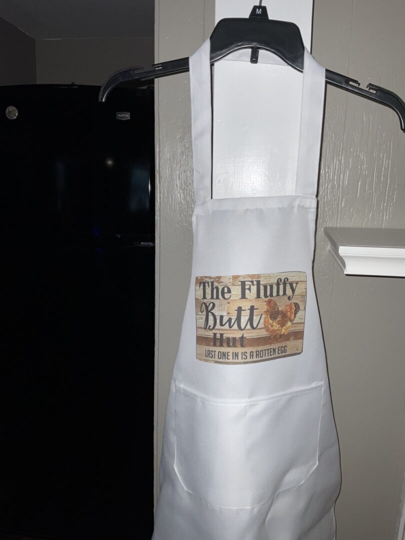 A white apron with the words " the fluffy butt ".