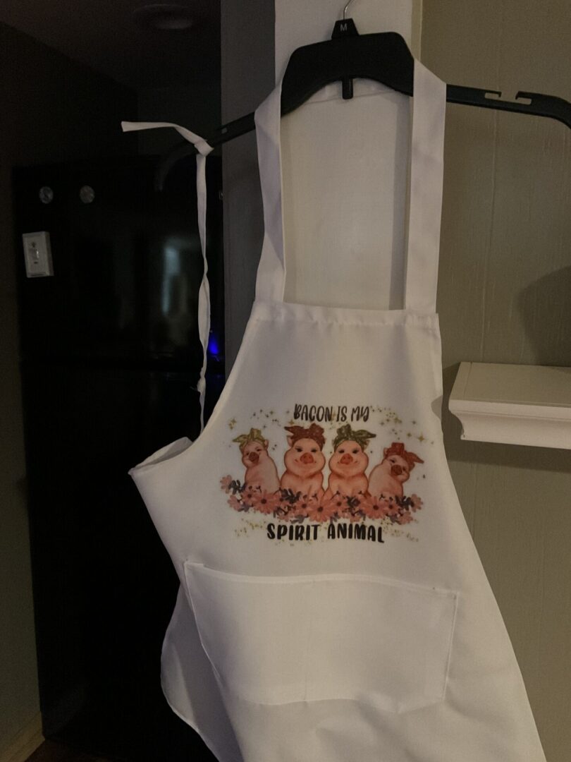 A white apron with three pigs on it.