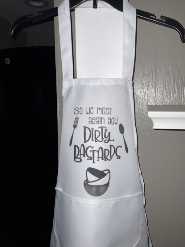 A white apron with an image of spoons and a bowl.