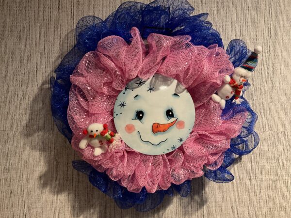 A pink and blue flower with a snowman face on it.