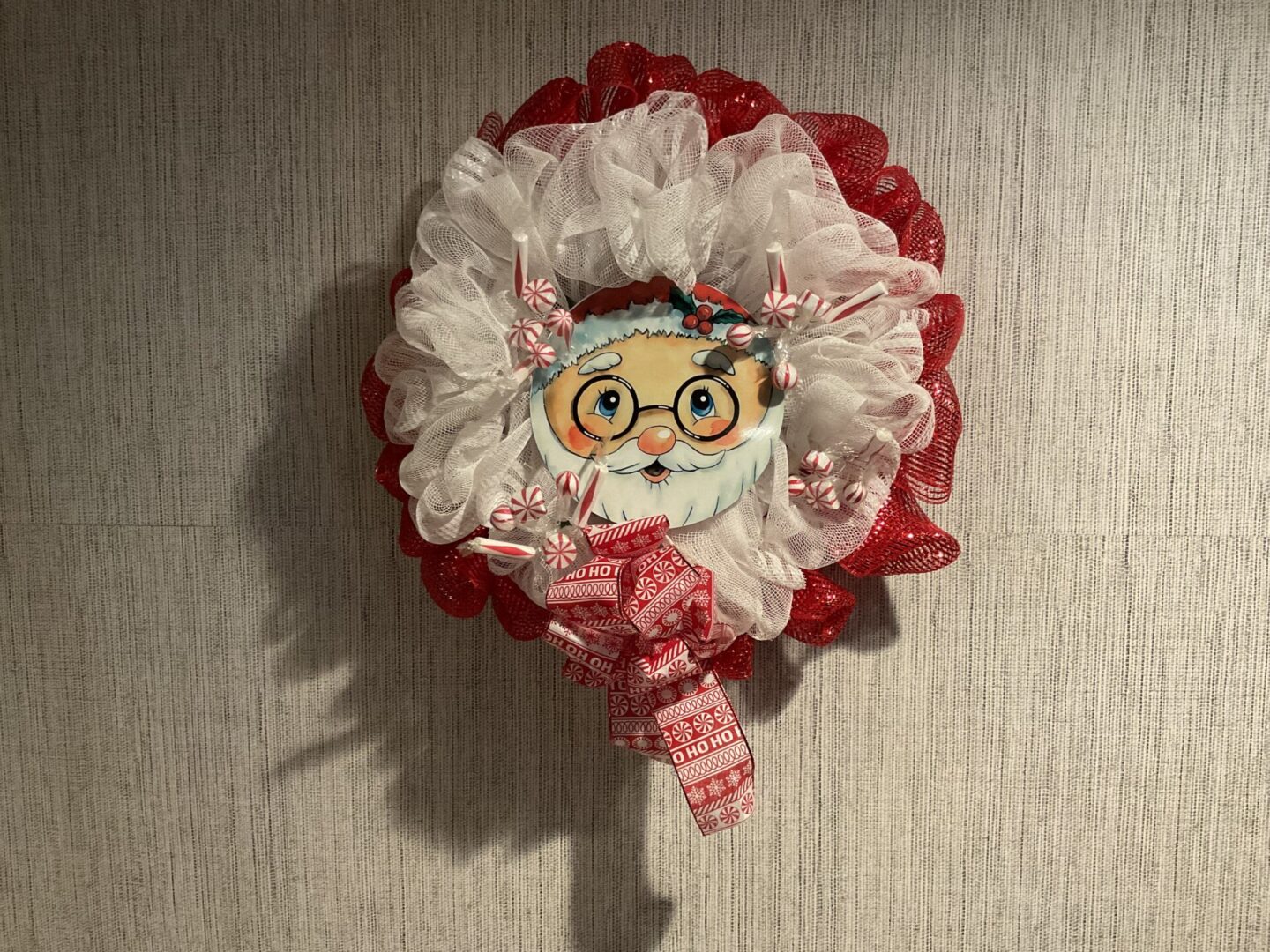 A red and white wreath with a face on it.