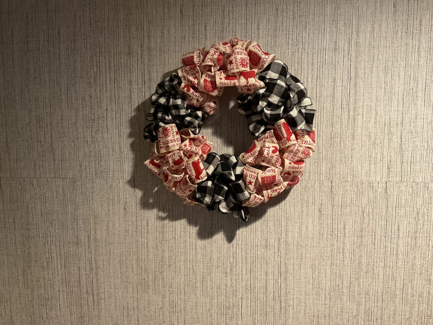 A wreath made of candy sitting on the wall.