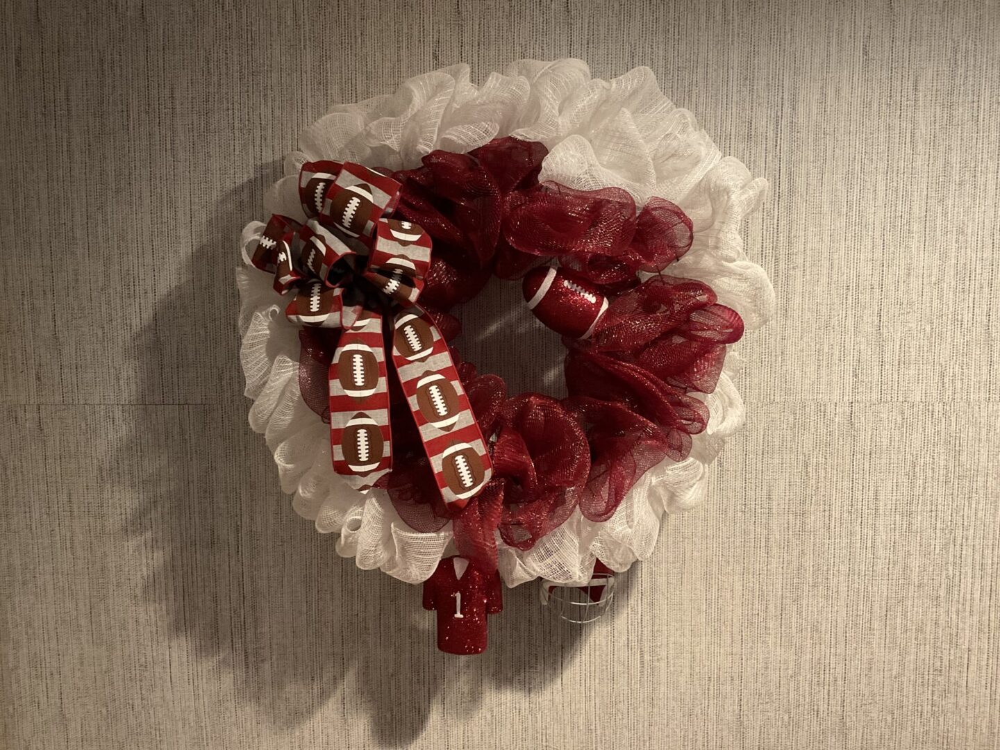 A wreath with a red and white ribbon on it.