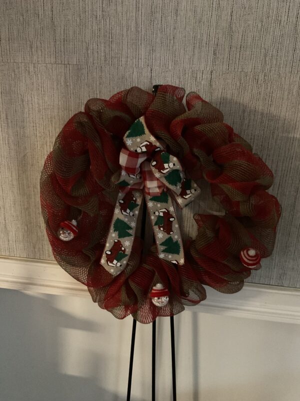 A red and white wreath with a bow on top of it.