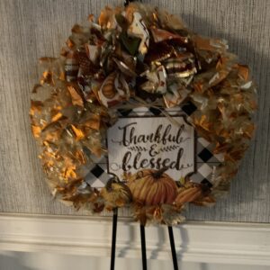 A wreath with leaves and a sign that says " thankful & blessed ".