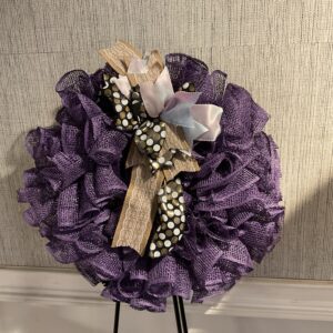 A purple wreath with a cross on it.