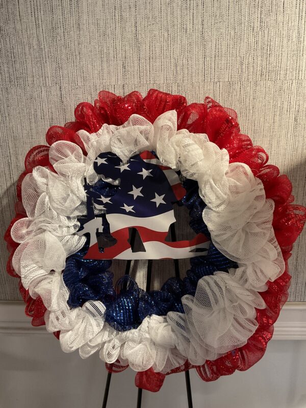 A wreath with red, white and blue ribbons.