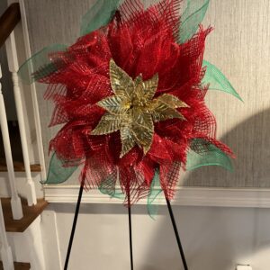 A red and green wreath on a stand