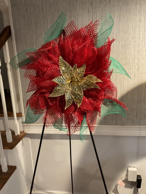 A red and green wreath on a stand