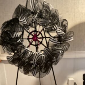 A black and white wreath on a stand