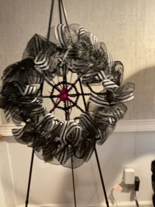 A black and white wreath on a stand