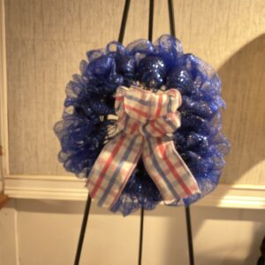 A blue wreath with a bow on top of it.