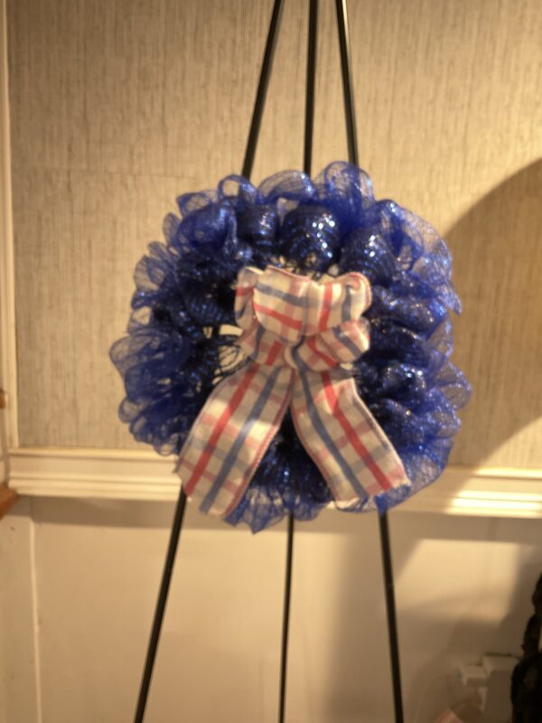 A blue wreath with a bow on top of it.