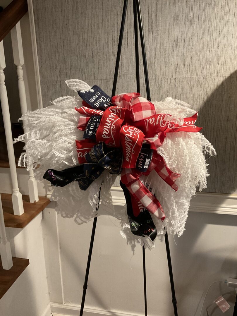 A wreath of white and red feathers with black ribbon.