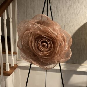 A large flower sitting on top of an easel.