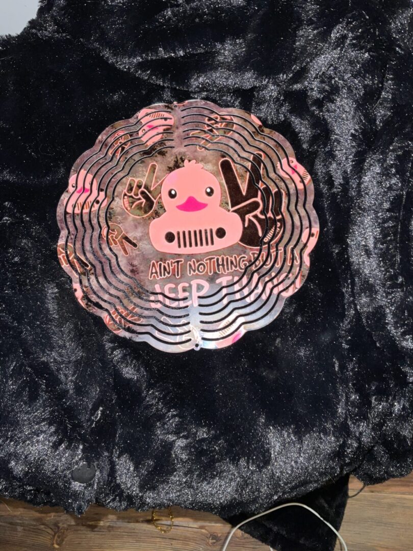 A black and pink pin with a pig on it