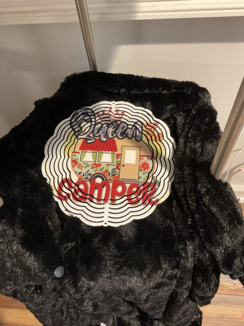 A black jacket with the words queen camper on it.