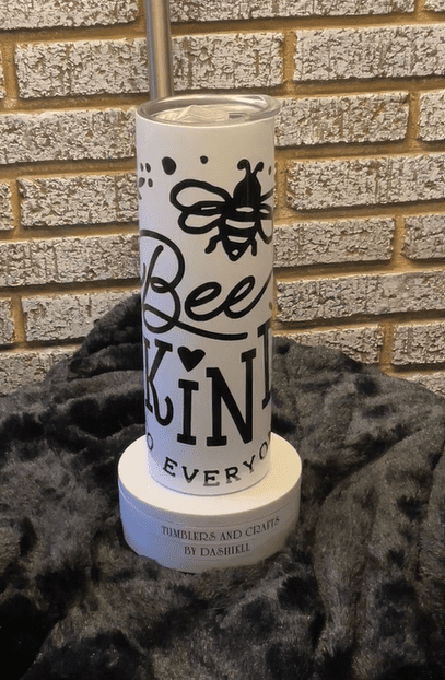A candle that says bee kind everywhere on it.